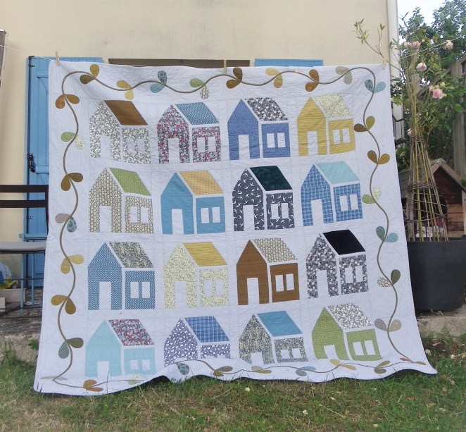 quilt avec maisons et guirlande de feuilles